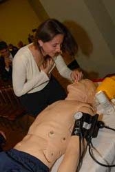 Alumni & Friends President Yvette Bocz '02 practices CPR with SimMan
