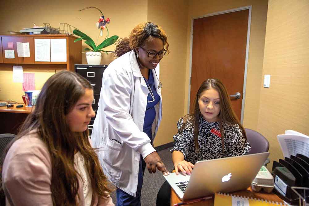 LaSonya Davis instructs nursing students Lorena Huizar (left) and Jacqueline Cuatepotzo