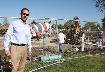 Jim Walsh poses in front of an infrastructure construction site