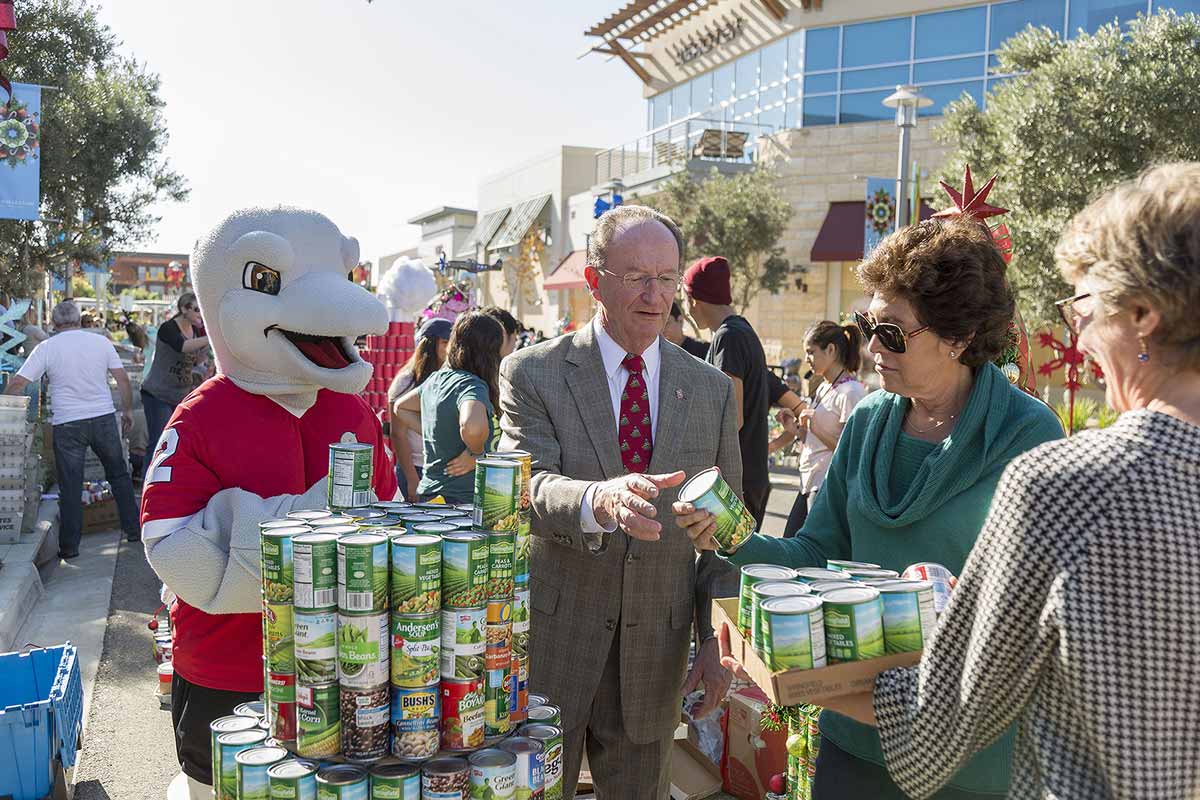 University mascot, Ekho, along with President Rush and his wife, Jane, and Chief of Staff Genevieve Evans Taylor, participate in the Ventura County Food Share Can Tree Drive.