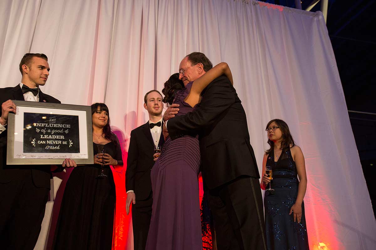 President Rush receives a plaque from President’s Scholars alumni at the tribute event.