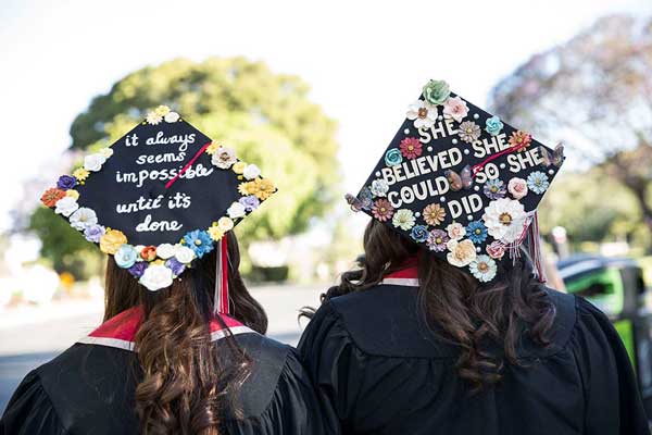 Students show off creative mortarboards.