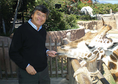 Professor Dennis Muraoka having a moment with a giraffe at the santa barbara zoo