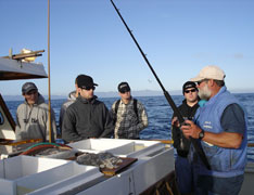 Students listen to the fisherman explain the day's activities before beginning to deep-sea fish.