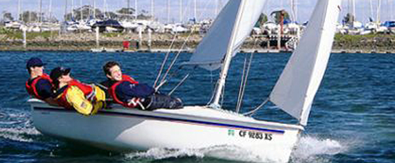 Image of three people sailing