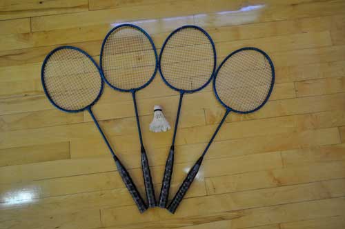 Four badminton racquets and a birdie