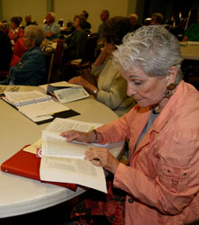Older person reading a book at table