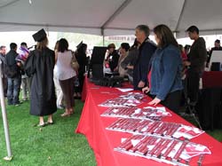 Volunteers tabling handing out license plate frames