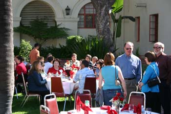 Group of CSUCI alumni sitting at a table in the south quad court yard