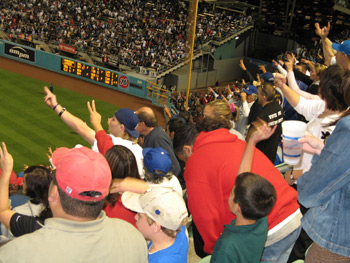 Large group of dodger fans with hands in the air