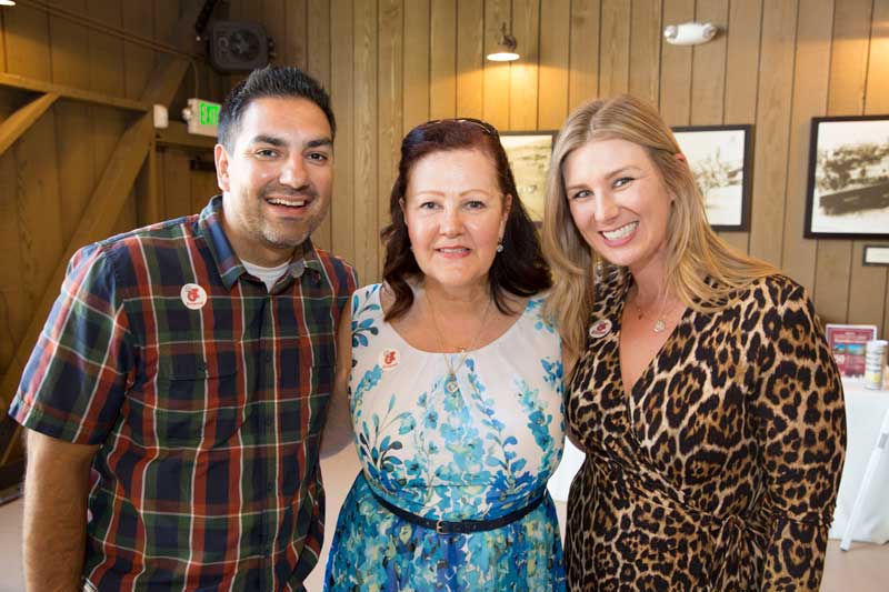 Three people in cabin smiling for the camera 