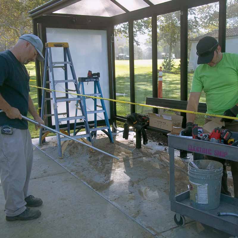 Two men fixing an electrical issue on campus