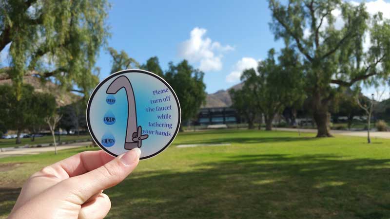 Student holding save water symbol