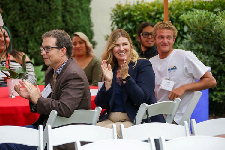 Dean Kohli sitting with Scholarship Recipients at scholarship reception in Presidents Courtyard