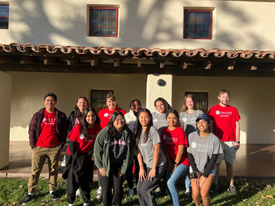 Desk Assistant team smiling in front of Santa Cruz Village