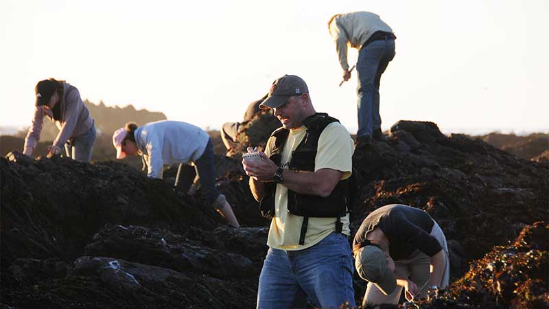 Sean Anderson taking notes at a dig site.