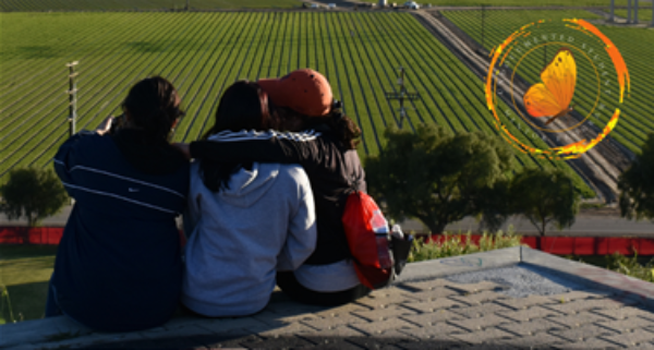 Three students facing a field