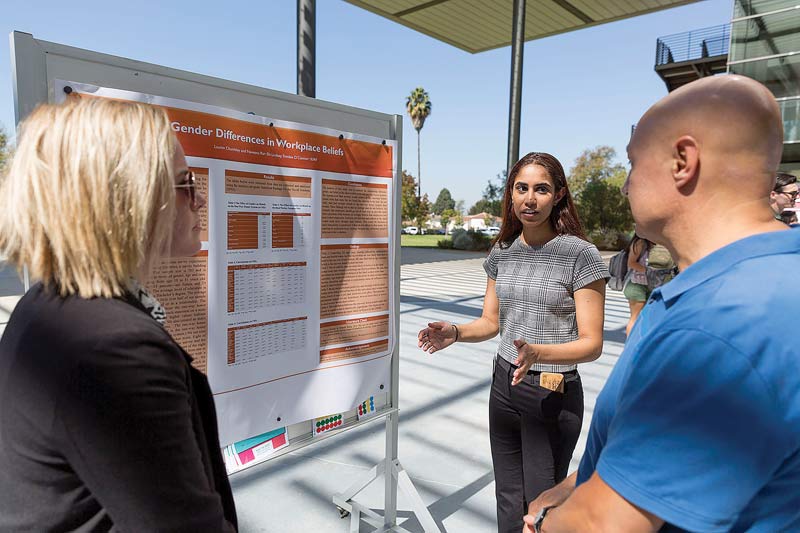 Lauren Chumbley (left) and Naveena Rai (right) present their research on Gender Differences in Workplace Beliefs.