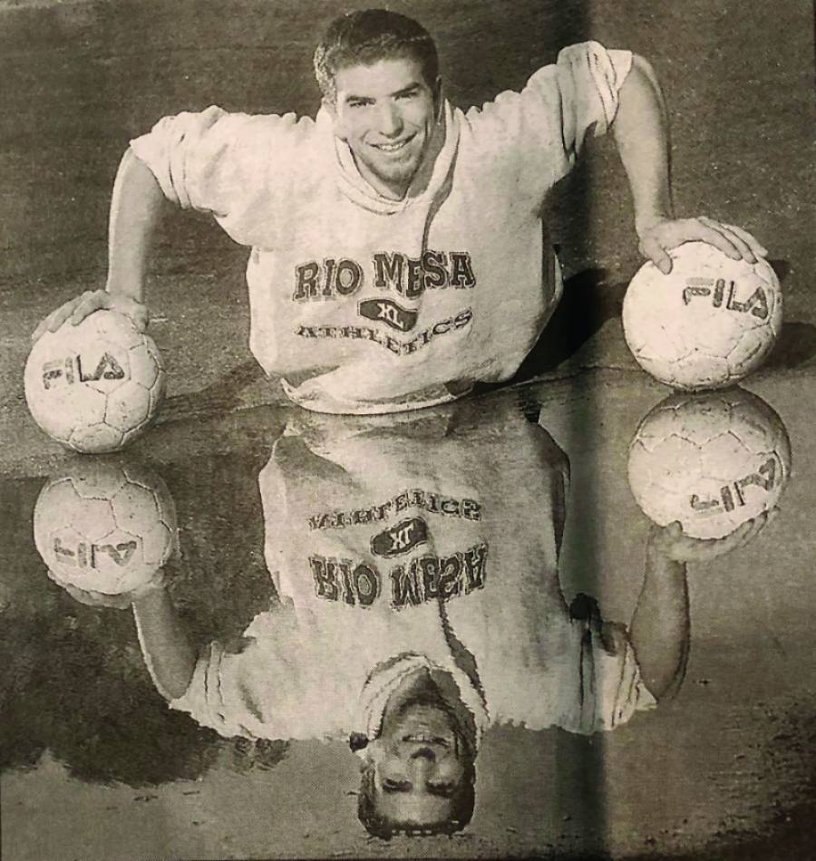 Trying not to fall in the puddle, Jonathan Johnen carefully balances on two soccer balls for this senior year photo at Rio Mesa High School.