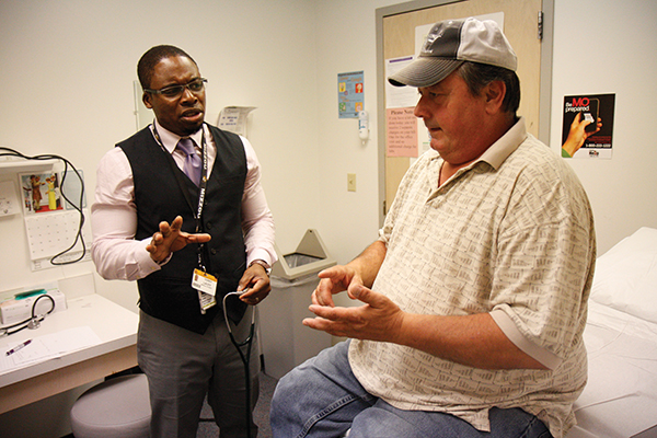 Ontario Lacey (left) talks with a patient