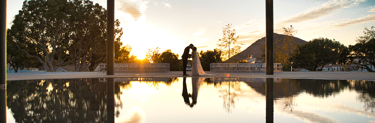 Lauren Gih and Ryan Stokes kissing in front of the Broome Library