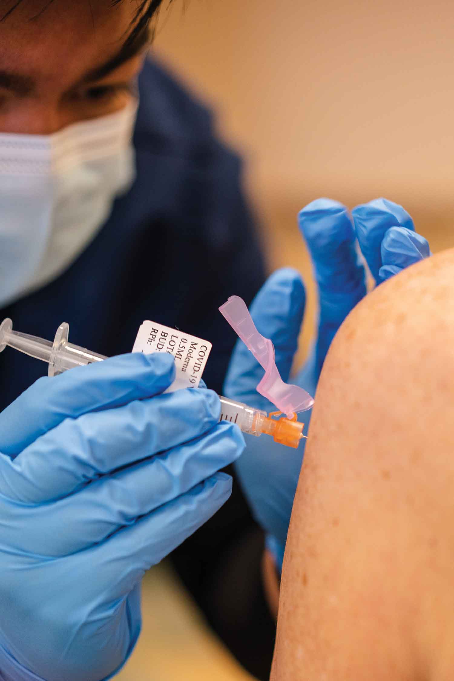  Nursing student Joshua Gonzalez administers a vaccine