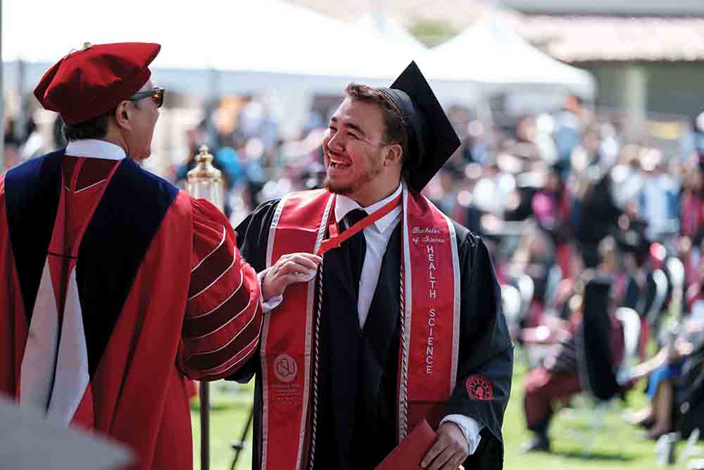 President Yao congratulates a graduating student. President Yao congratulates a graduating student.
