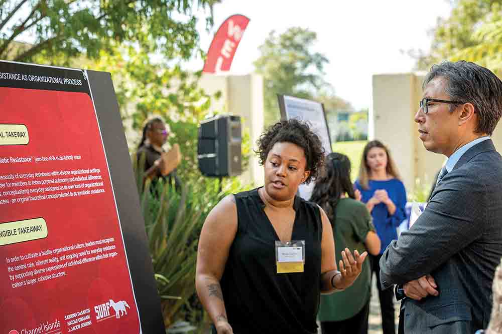 President Yao engages with a student about her research projects. President Yao engages with a student about her research projects.