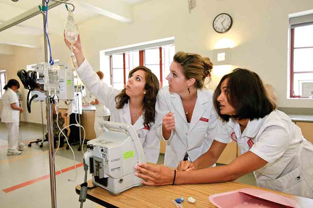  Nursing students work with a saline drip. 