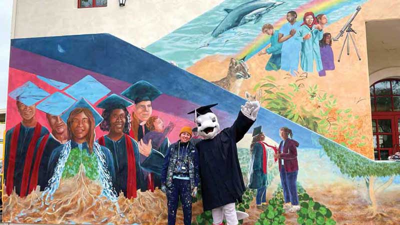 Ekho celebrates the finished mural with artist Myisha Arellano.