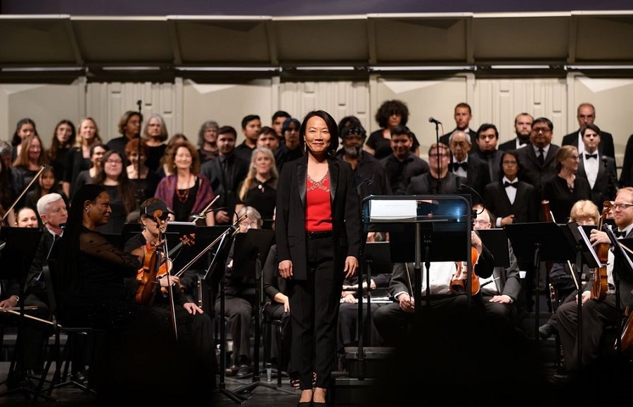 KuanFen Liu stands in front of the choir and chamber orchestra after finising a performance