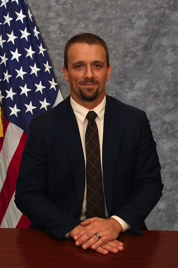 Portrait of Robert J. Stukes next to an American flag