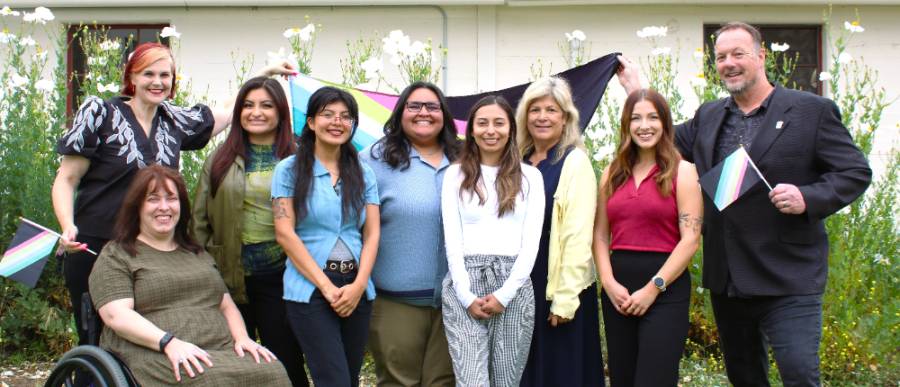 DASS Team Photo of the 9 DASS staff members and the disability pride flag