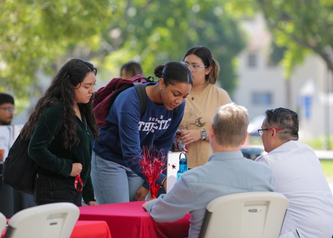 two students at an Major Fair table filling out an interest form