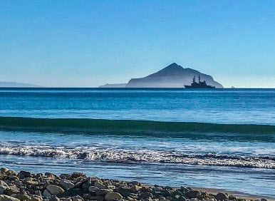 Image of a naval ship passing in front of Santa Rosa Island.