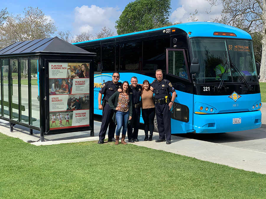 Group of people standing in front of VCTC Bus at campus bus stop.