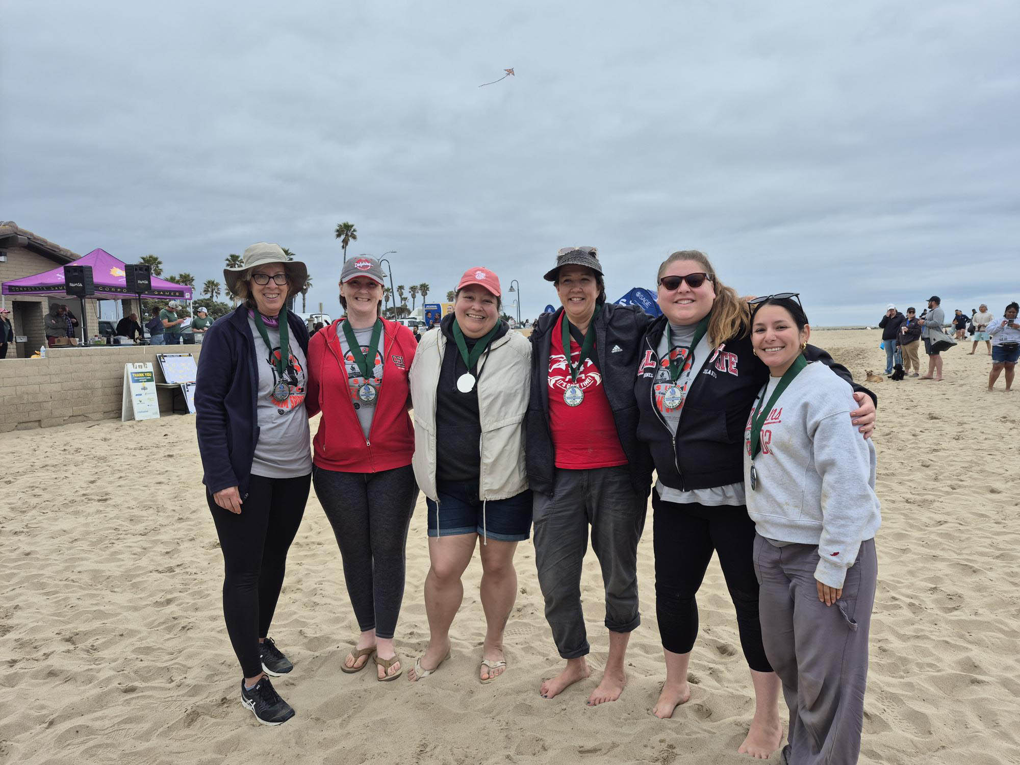 Six people wearing silver medals posing for the camera