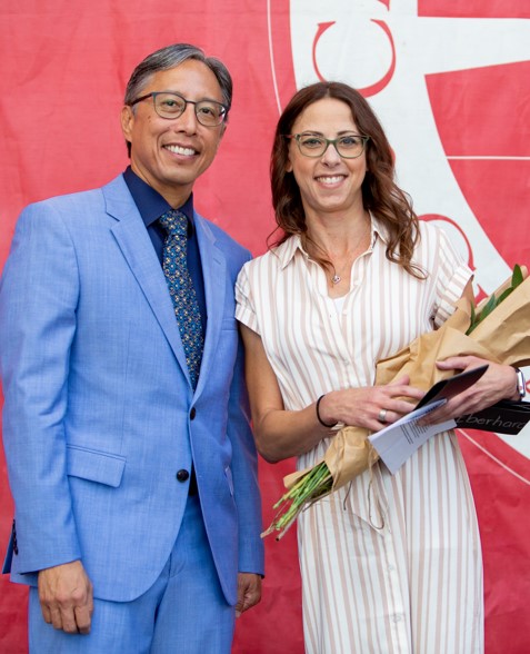 staff awardee, megan eberhardt-alstot, holding flowers with president yao