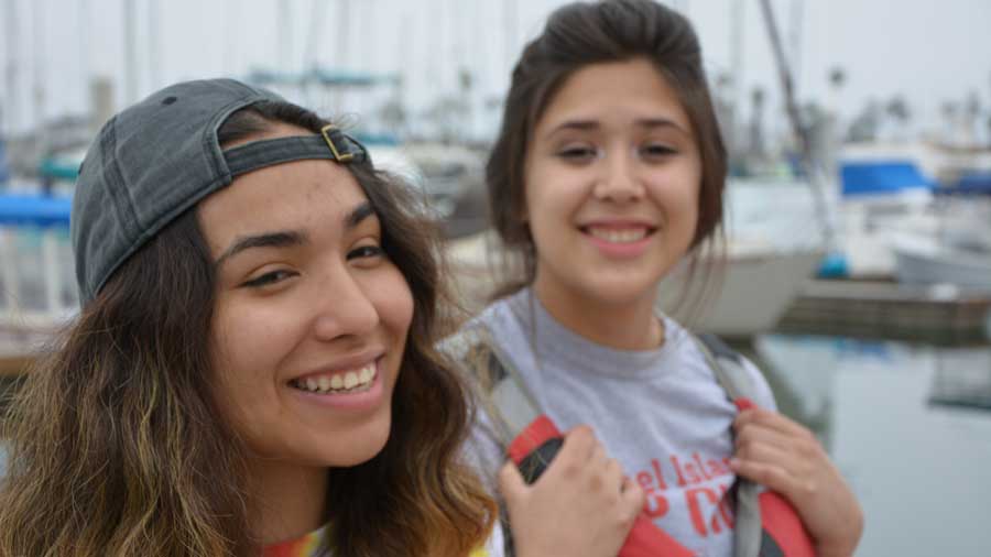 two students smiling at the harbor